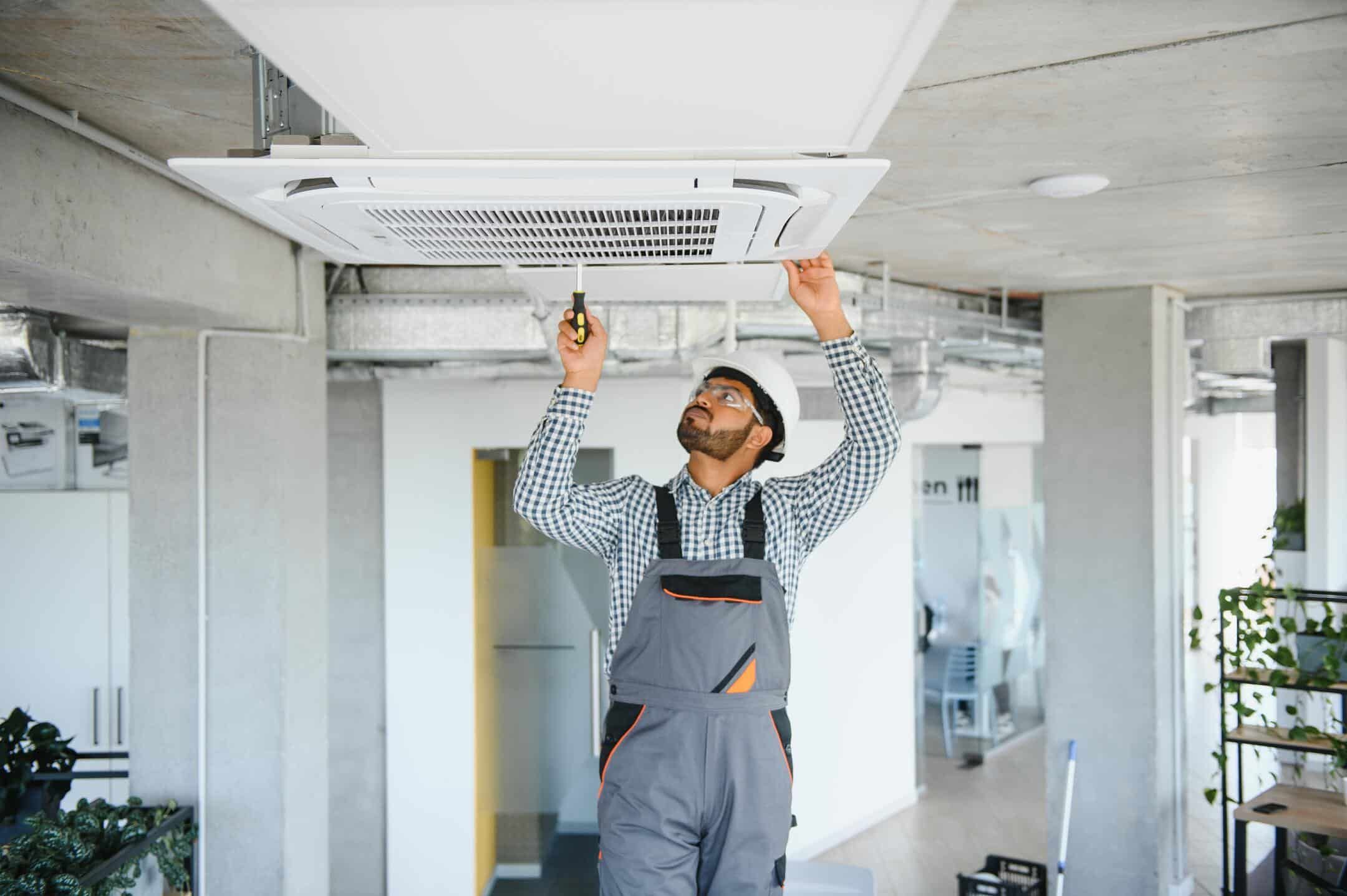 ac tune up cost-technician inside a home checking interior components of HVAC unit ac tune up cost-technician inside a home checking interior components of HVAC unit