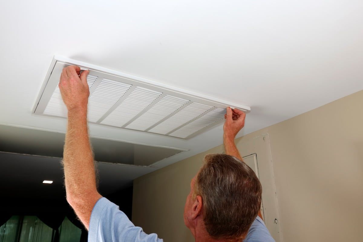 man replacing hvac air purifier filter man replacing hvac air purifier filter