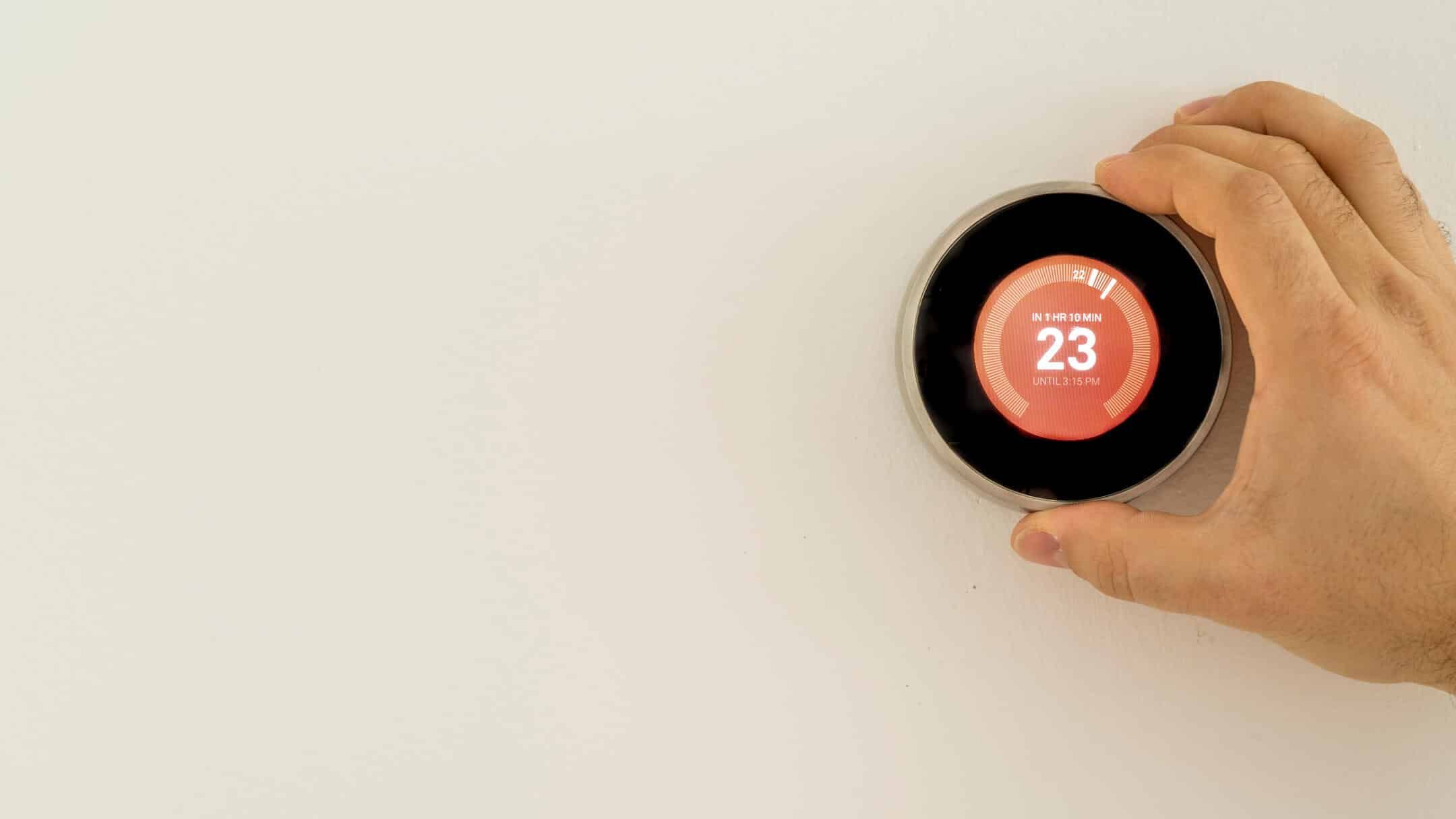how to calibrate a thermostat-hand adjusting a dial thermostat how to calibrate a thermostat-hand adjusting a dial thermostat