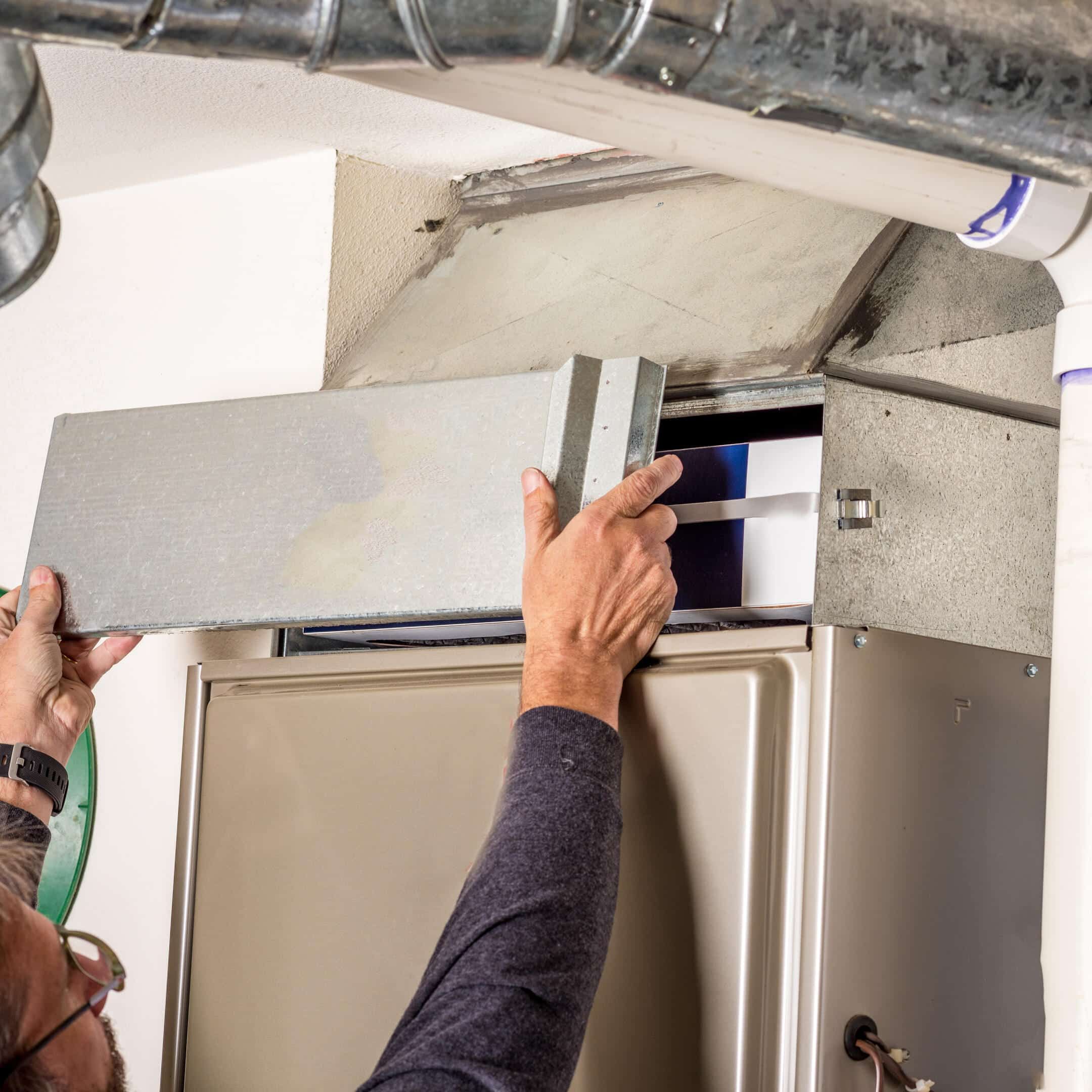 furnace replacement-person removing a door on a furnace furnace replacement-person removing a door on a furnace