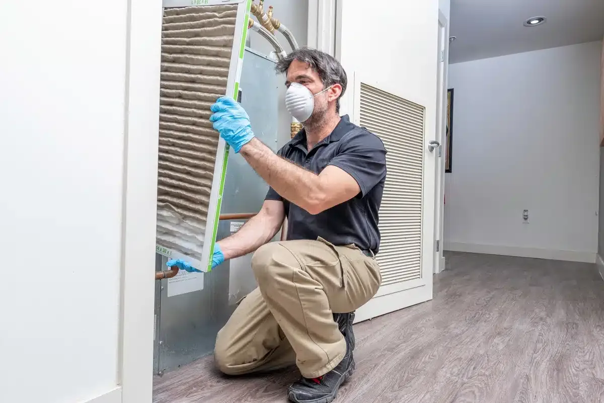 a man wearing a mask and gloves holding a air filter a man wearing a mask and gloves holding a air filter