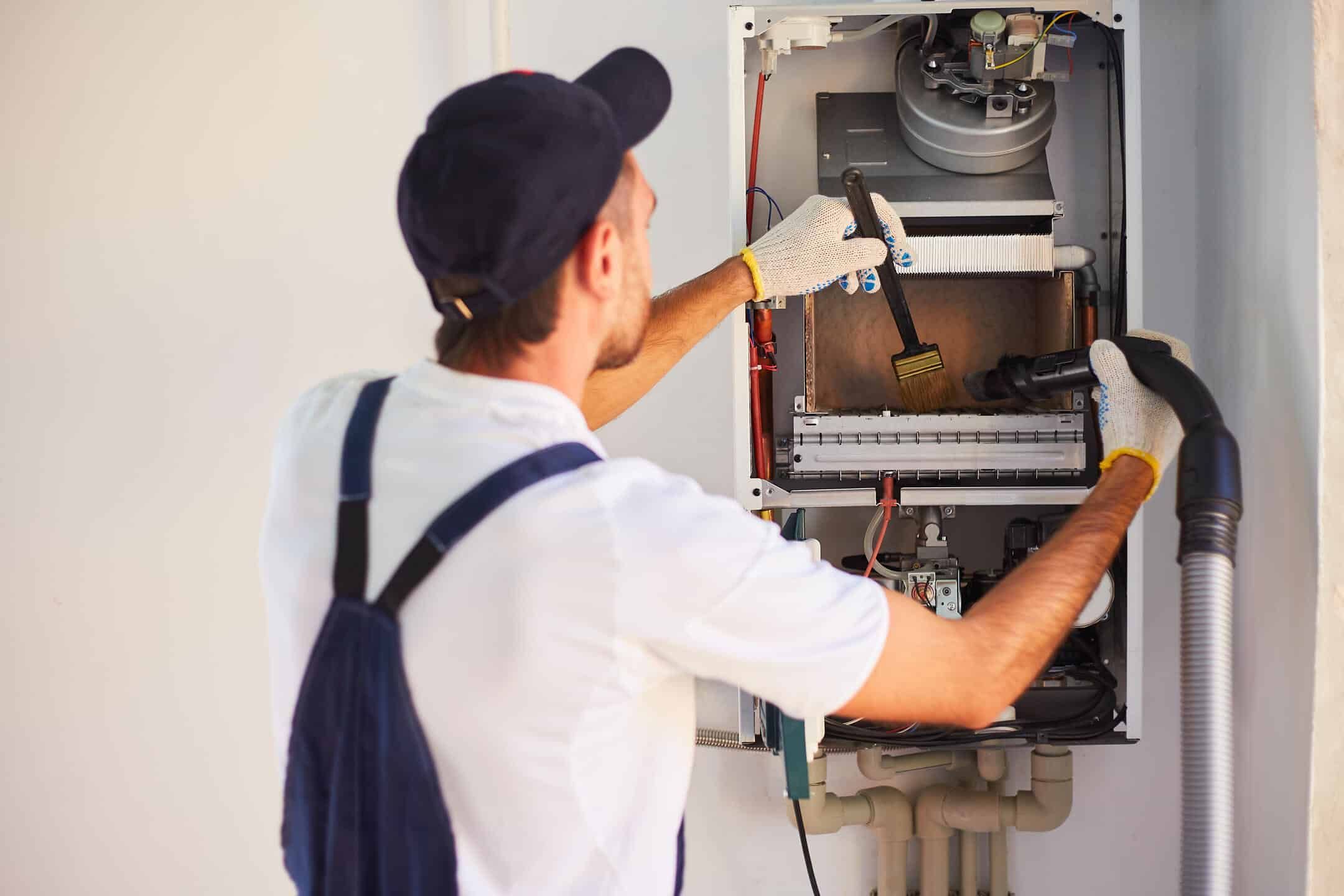 heating system repair-repair tech doing maintenance on a heating system heating system repair-repair tech doing maintenance on a heating system