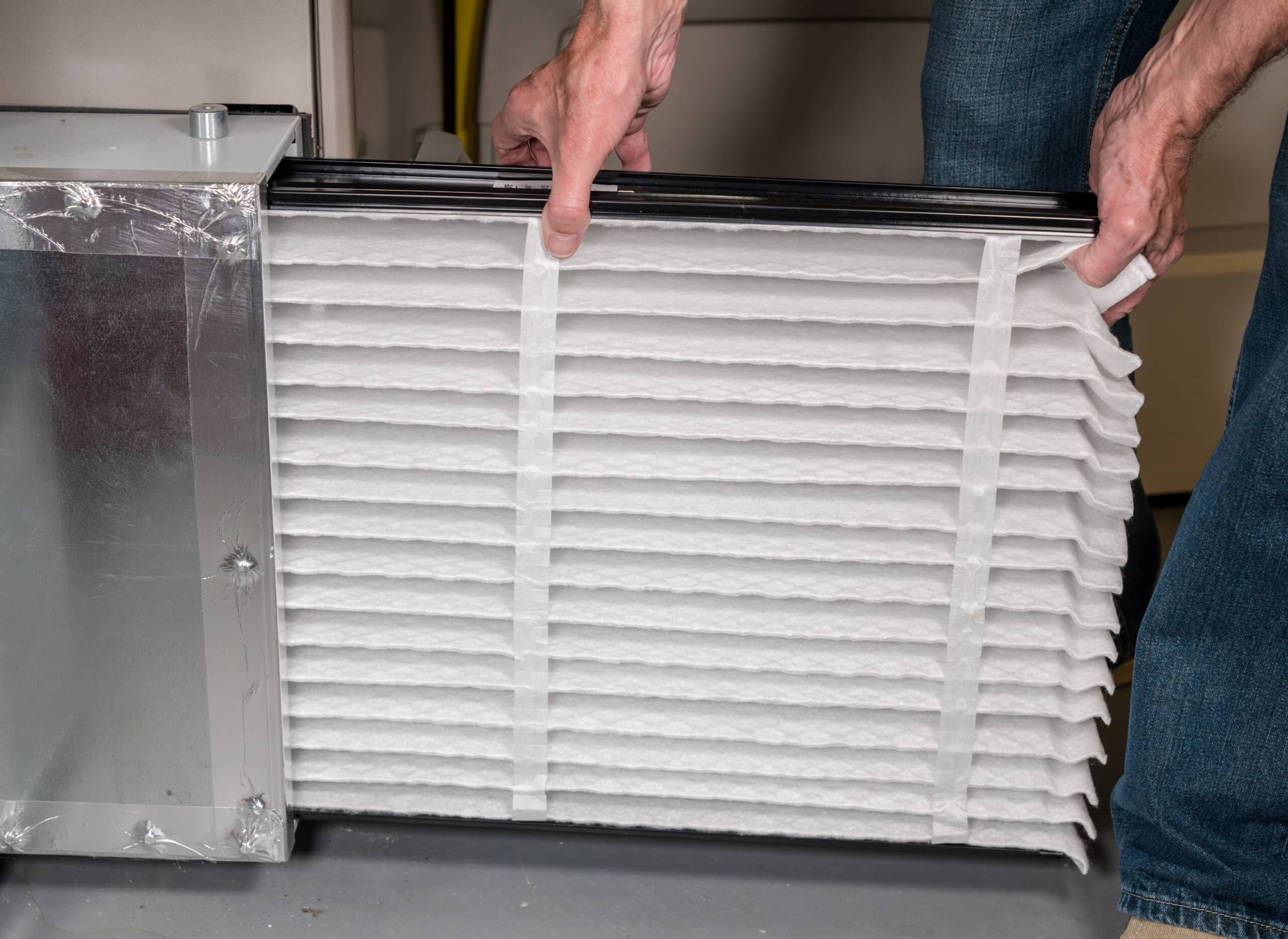 man inserting new filter to furnace man inserting new filter to furnace