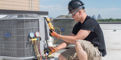 Hvac technician inspecting an condensing unit.