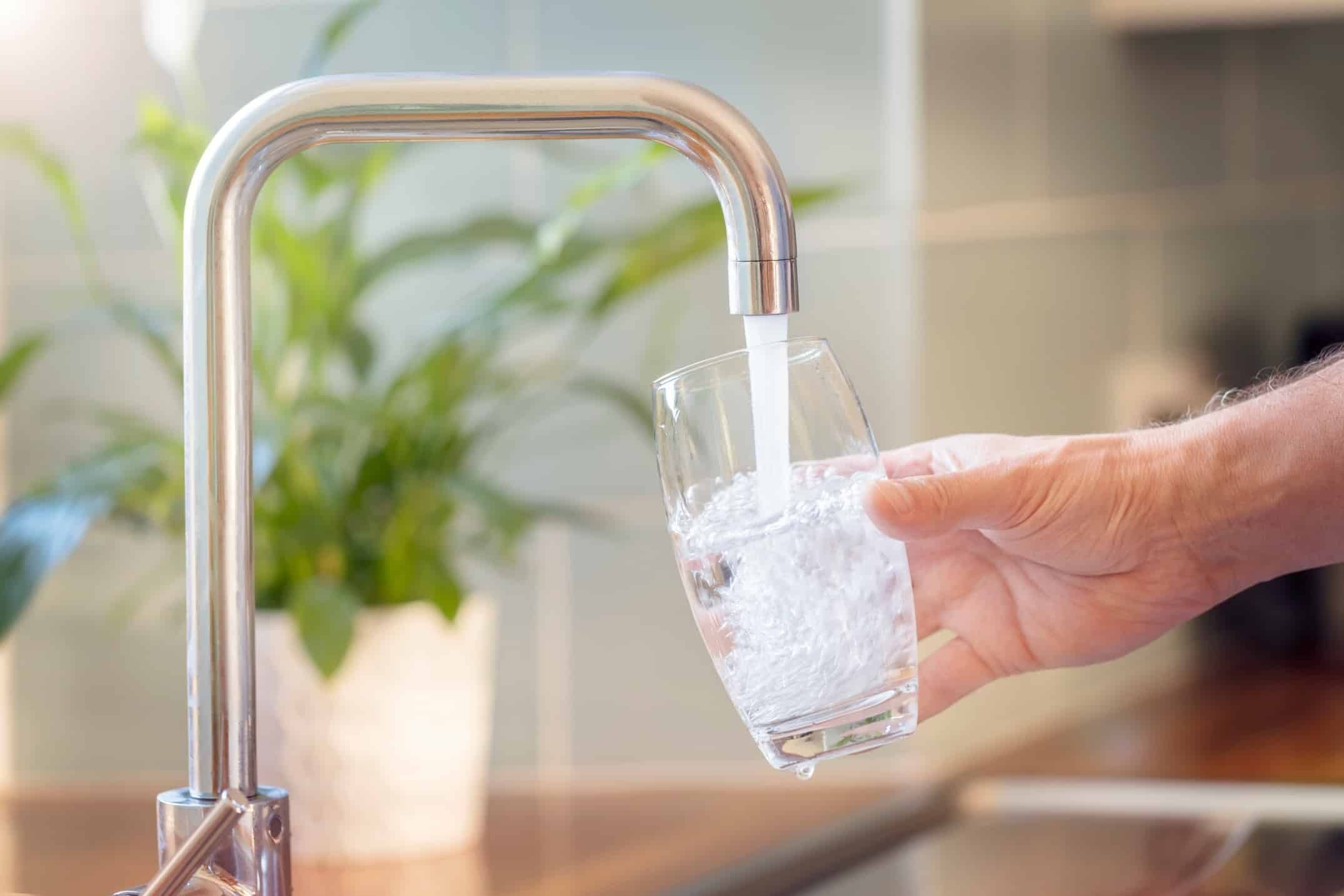 Filling up a glass with clean drinking water from kitchen faucet Filling up a glass with clean drinking water from kitchen faucet