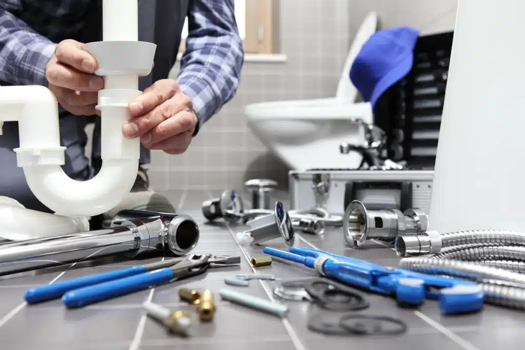 plumber working on a drain system on the bathroom floor