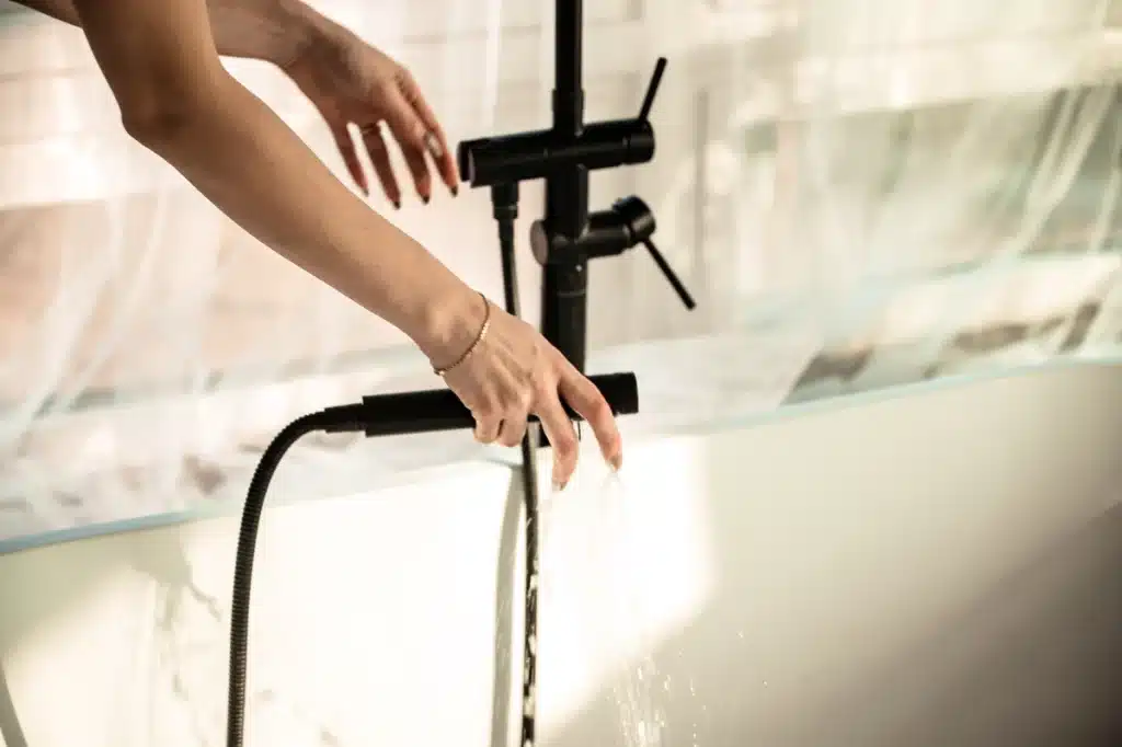 woman holding shower head whose shower won't turn off
