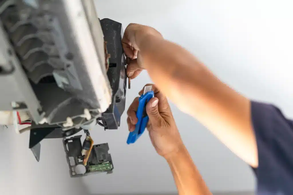 emergency furnace repair-close up of technician using utility knife while repairing furnace