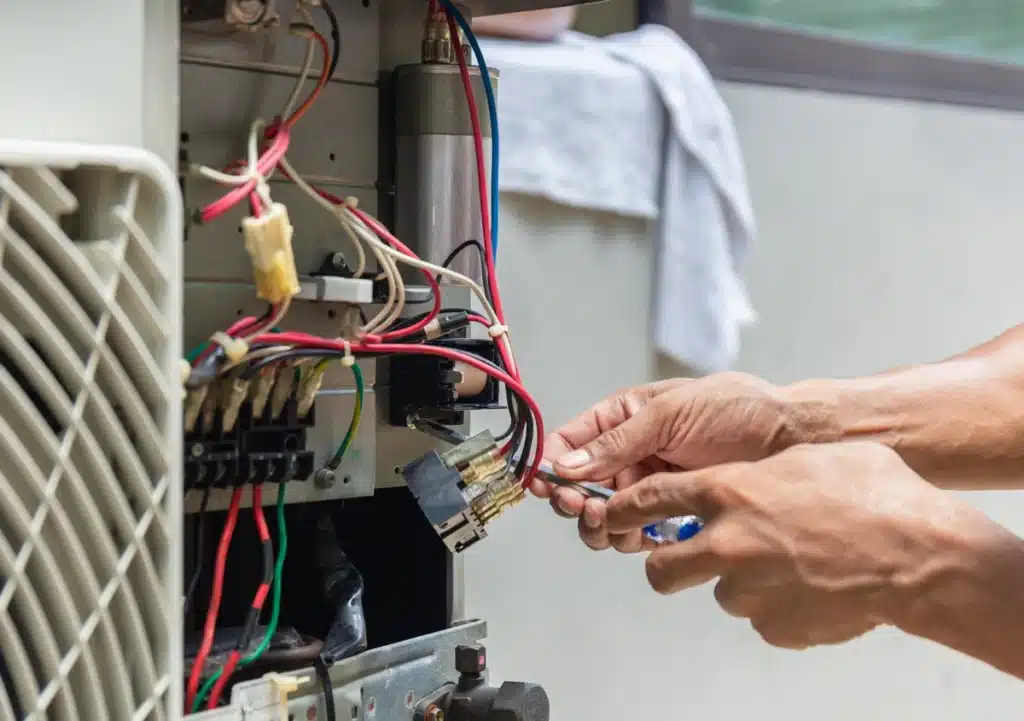 emergency furnace repair-technician using hand tools to repair furnace