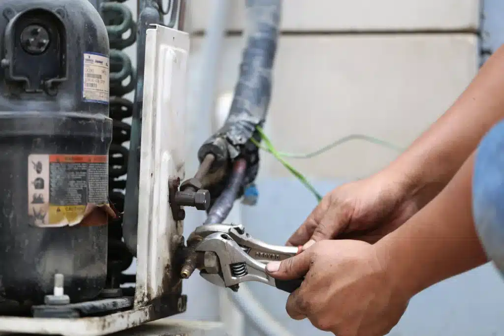 furnace replacement cost-technician using hand tools to do maintenance on furnace
