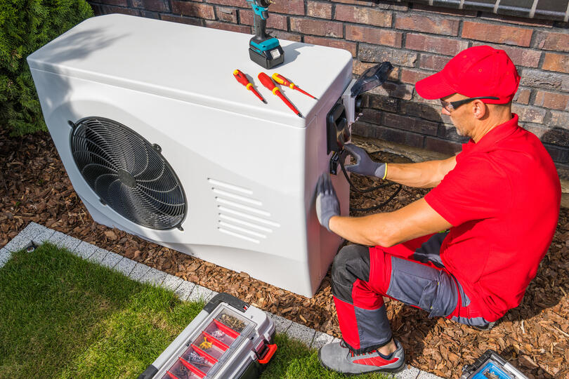ac unit cost-technician installing a new AC unit