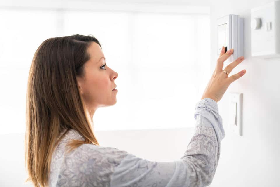 how to calibrate a thermostat-woman trying to adjust her thermostat