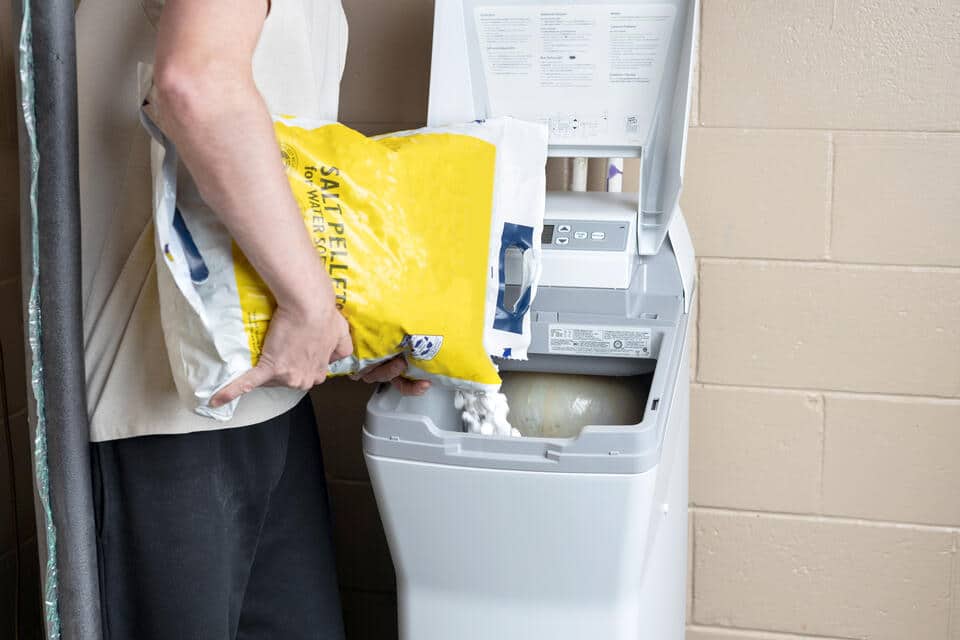 best water softener salt-man pouring water softener salt into brine tank
