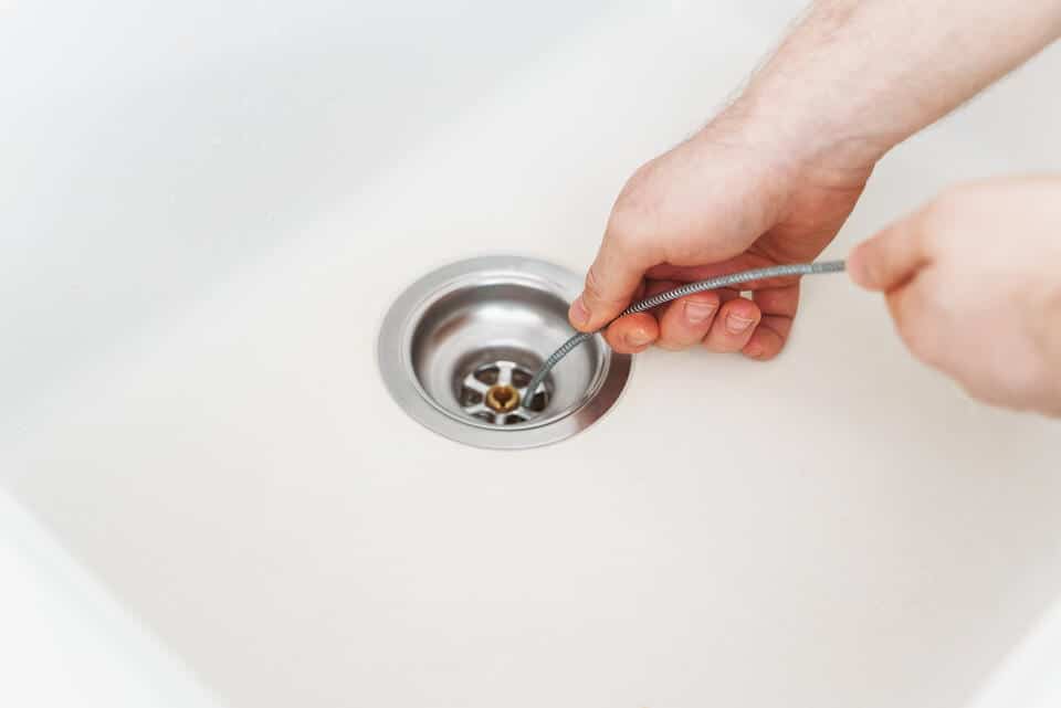 how to unclog sink-person using a snake to try to unclog a sink