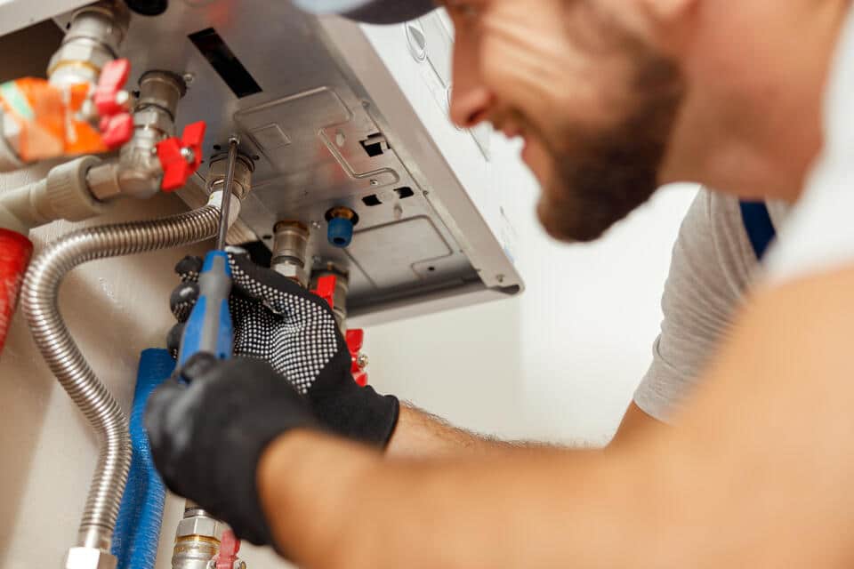 heating system repair-close up of repair tech doing maintenance on heating system