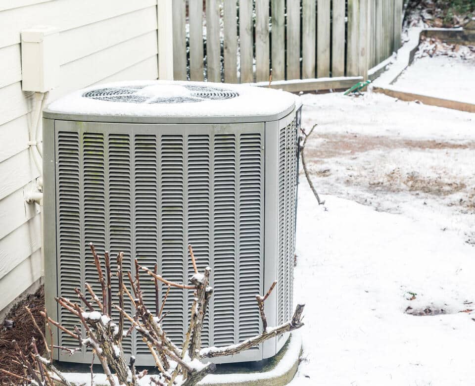 how does a heat pump work in winter-close up of heat pump outside of a white house
