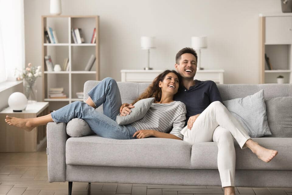 hvac refrigerant-couple lounging on their couch, comfortable inside their home