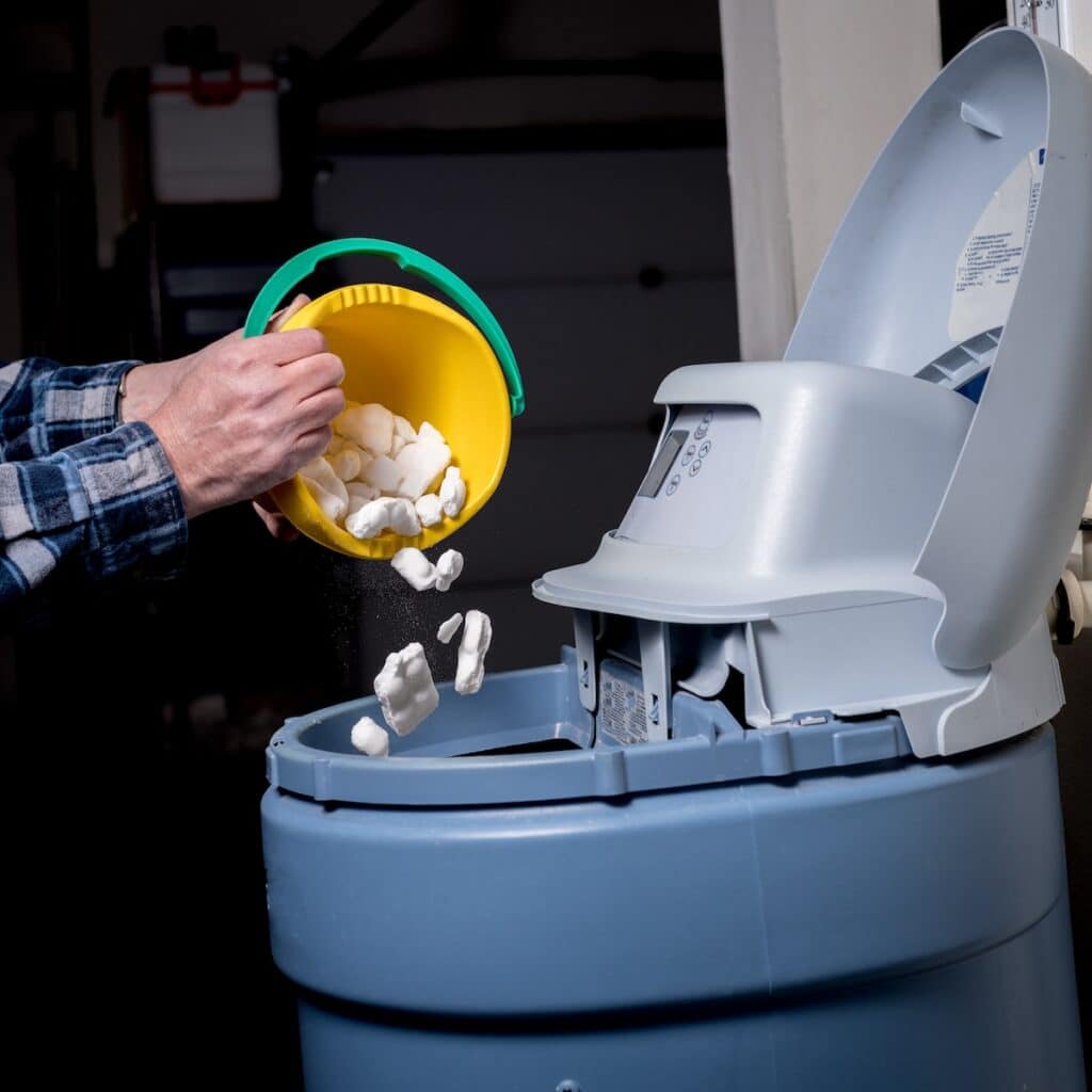 person putting in water softener