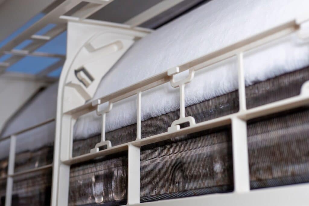 close-up of Frozen or Ice in the air conditioning. Problems with home cooling systems are caused by leaks in heating pipes, hot and cool coils, air pressure, and chemicals.