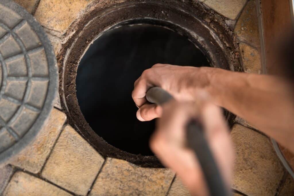 Worker performs the installation of pumping equipment. Sewer cleaning