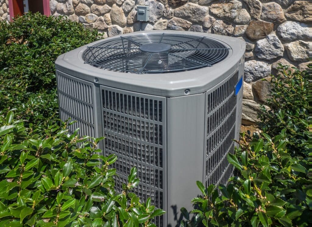 Air conditioning and heating unit for a residential house hidden by holly